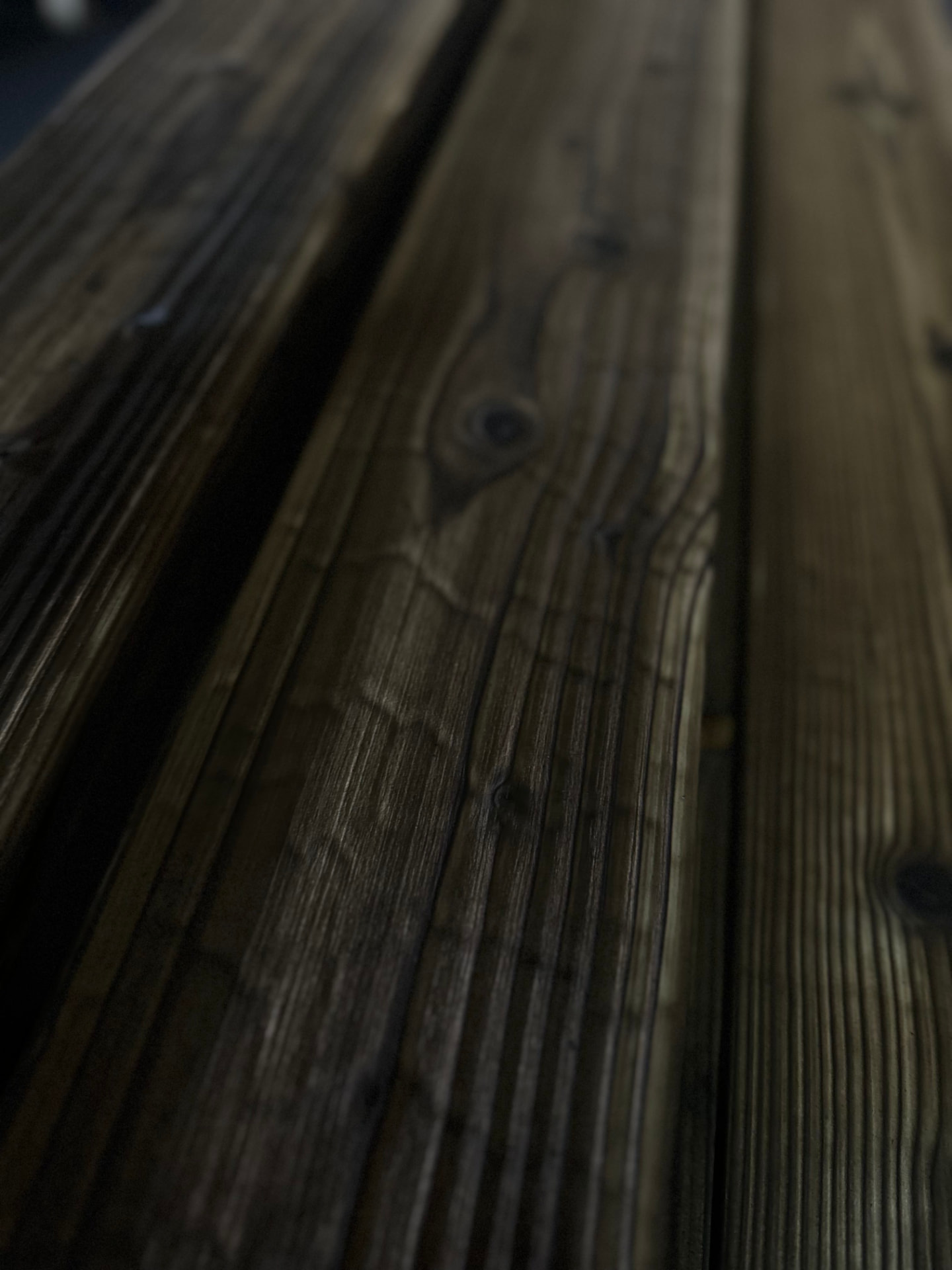 Brushed charred timber boards with warm grain, knots and natural tonal variation